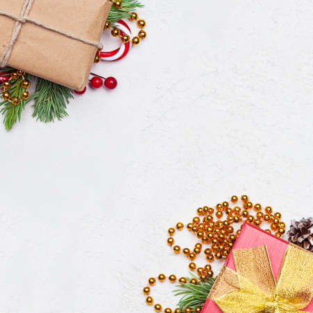Christmas card background with gifts, holly berries and green fir branch on white background. Xmas flat lay top view with copy spaceの写真素材