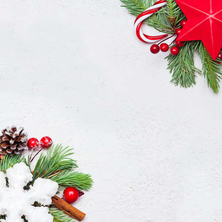 Christmas composition. Red stars, holly berries, snowflake and green fir branch on white background. Xmas flat lay top view with copy spaceの写真素材