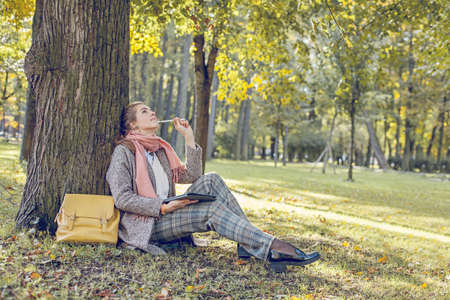 Real businesswoman with tablet laptop at work outdoors in parkの写真素材