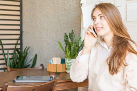 Business woman with smartphone working in open office placeの写真素材