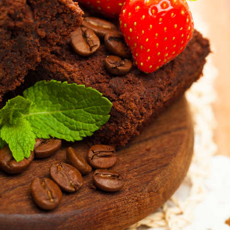 Strawberry on chocolate cake with green leaves coffee grainの写真素材