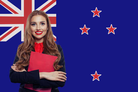 Happy student girl with book against the New Zealand flagの写真素材