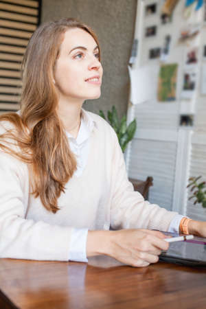Pretty business woman sitting with laptop gadget and working in officeの写真素材