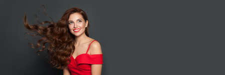 Beautiful woman with long healthy brown curly hair. Gorgeous model with natural makeup and perfect hairstyleの写真素材