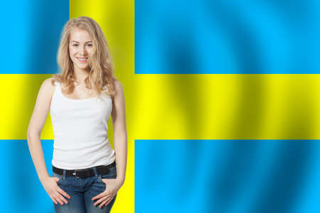 Sweden. Happy cute student girl with the Sweden flag background. Travel and learn Sweden languageの写真素材