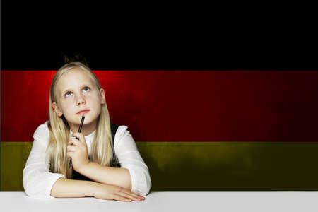 Thinking child girl student against the Germany flag background. Deutsch conceptの写真素材