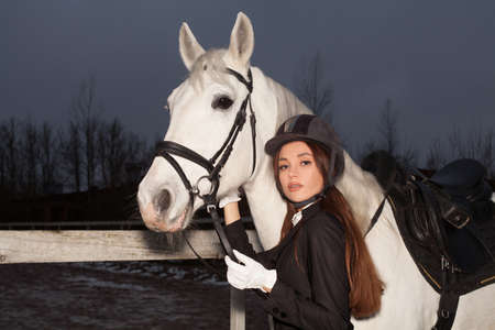 Elegant woman jockey with white horse, ride lesson
