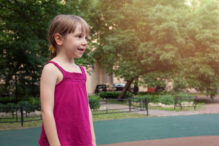 Little Girl Playing In A City Garden In summerの写真素材