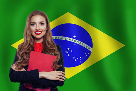 Brazil concept with cute woman student against the Brazilian flag background. Travel in Brazil and...