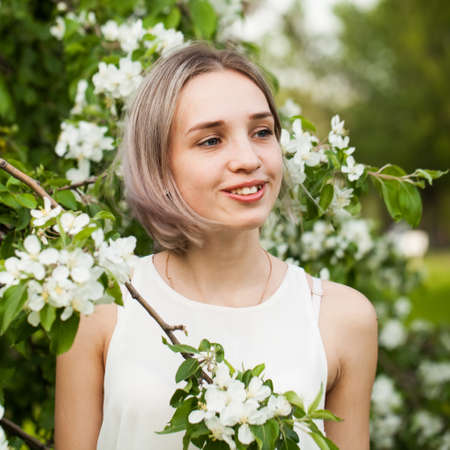 Happy young teen woman in flowers garden outdoors