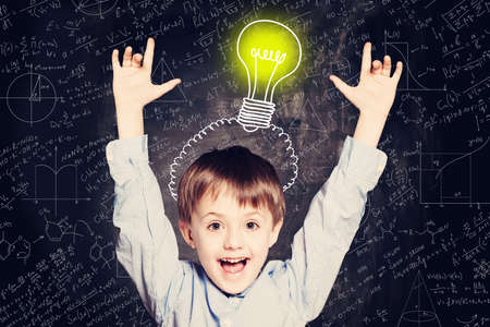 Child boy with hands up and lightbulb. Concept Ideas and projectsの写真素材