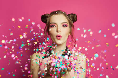 Attractive woman with colorful confetti on pinkの写真素材