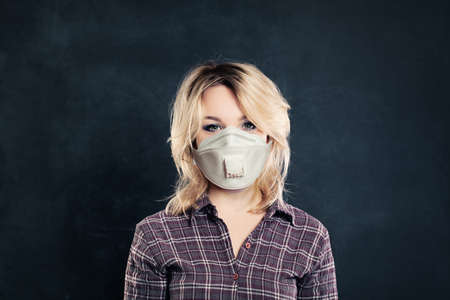 Woman in medical face mask on black backgroundの写真素材