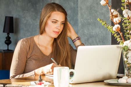 Pretty Woman using laptop and graphics tablet at homeの写真素材