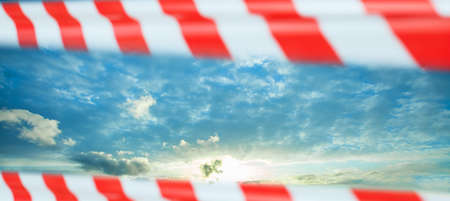 Sky, clouds and red warning tape. Prohibition, quarantine, canceled flights and deferred vacation...
