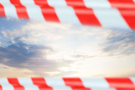 Sky clouds with red warning tape, prohibition conceptの写真素材