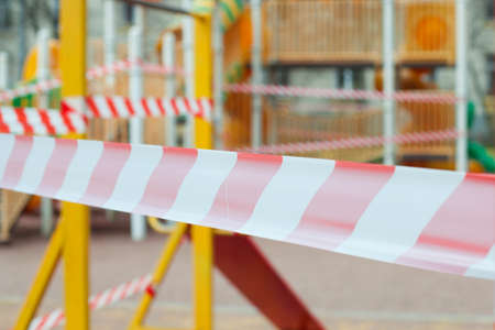 Closed playground with red warning tapeの写真素材