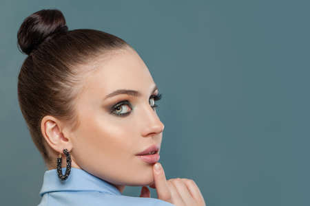 Cheerful brunette woman on blue background. Perfect face closeupの写真素材