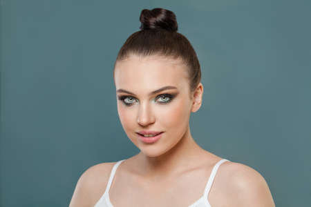 Nice woman with clear healthy skin on blue, portrait