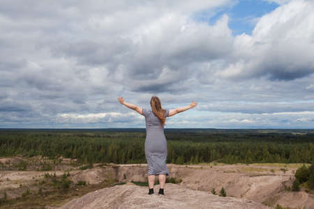 Carefree woman against sky clouds outdoorsの写真素材