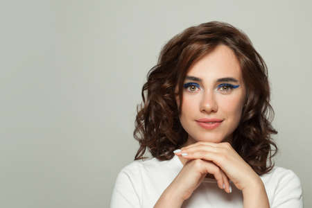 Lovely young woman with clear skin and dark curly hair portraitの写真素材