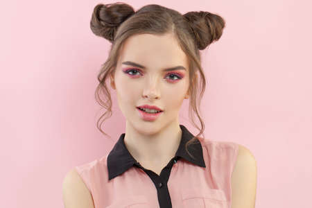 Young pretty model woman with fashion makeup on pastel pink backgroundの写真素材