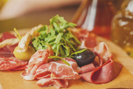 Charcuterie board with prosciutto ham, salami, herbs and olive antipasti. Gourmet platters
