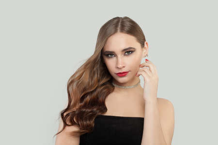 Beautiful young woman with brown curly hair on white background
