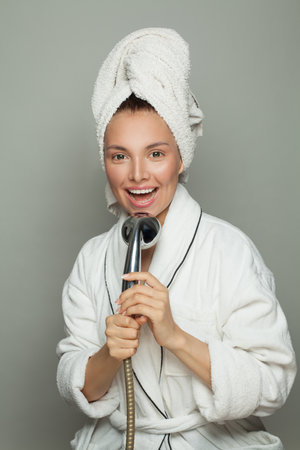 Pretty spa model woman singing with shower on white backgroundの写真素材