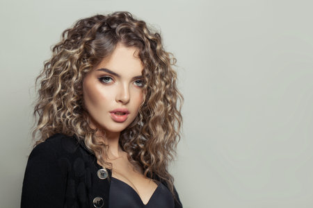 Perfect young woman with curly hairstyle on white banner backgroundの写真素材