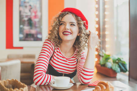 Smiling woman drinking coffee in cafeの写真素材