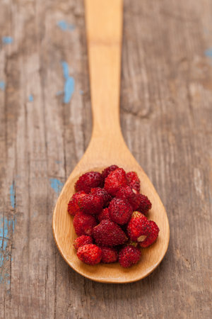 Strawberries in brown wooden spoon on vintage gray wooden backgroundの写真素材