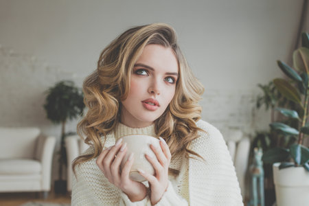 Nice woman drinking coffee at homeの写真素材