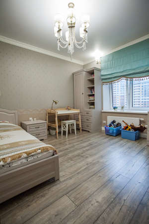 Children's room interior with wooden bed, table and wardrobeの写真素材