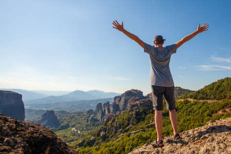 Young man overlooking mountain and sky and enjoying vacation