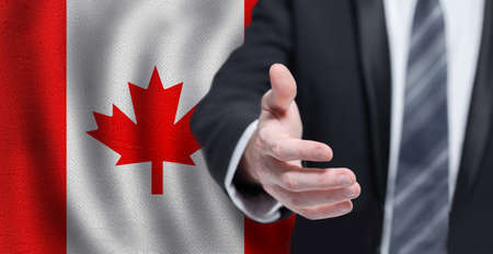 Canadian business, politics, cooperation and travel concept. Hand on flag of Canada background.の写真素材