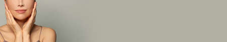 Close up female face on gray banner background with copy spaceの写真素材