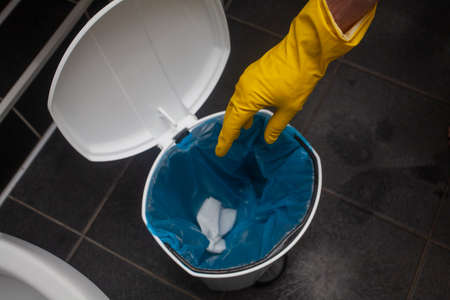 Toss napkin into trash in the bathroom. Disposing toilet paper, putting toilet paper in trash is a must.の写真素材