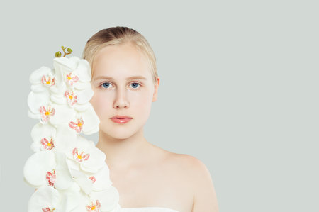 Young teen girl with healthy clean skin, natural makeup and white flowers. Spa, wellness, facial treatment and skin care conceptの写真素材