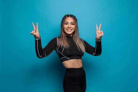 Optimistic active sporty woman having fun on blue background