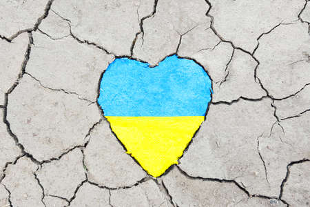 Heart with flag of Ukraine on cracked earth backgroundの写真素材