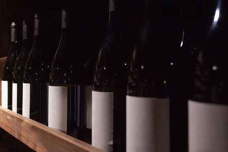 Racks with bottles in a dark wine cellarの写真素材