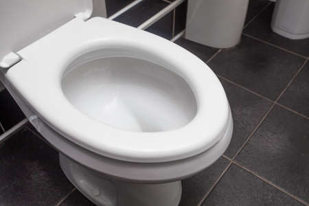 White toilet wc on black tiles closeupの写真素材