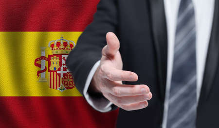Spanish business, politics, cooperation and travel concept. Hand on flag of Spain background.の写真素材
