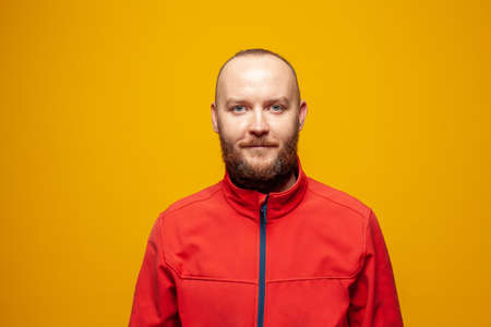 Handsome man with beard smiling on bright yellow backgroundの写真素材