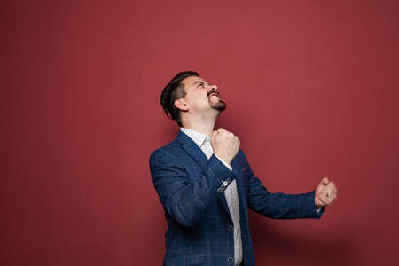 Winning success man happy ecstatic celebrating being a winner. Dynamic energetic image of male model in suitの写真素材