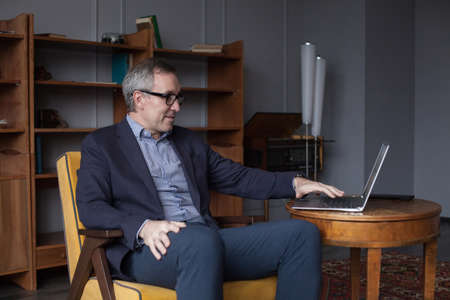 Old man using social network technology at home