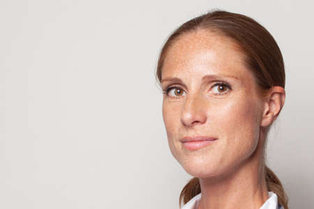 Natural beauty. Portrait of middle-aged woman with freckles closeup