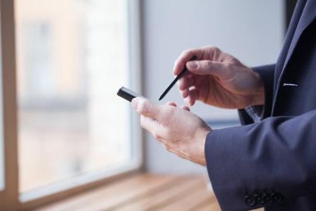 Smartphone and stylus in male handsの写真素材