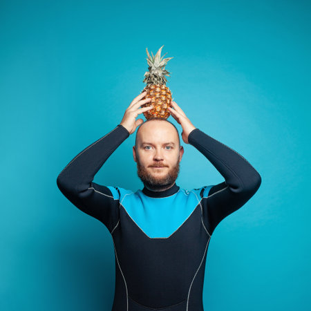 Travel concept. Man diver with pineapple on his head on blue backgroundの写真素材